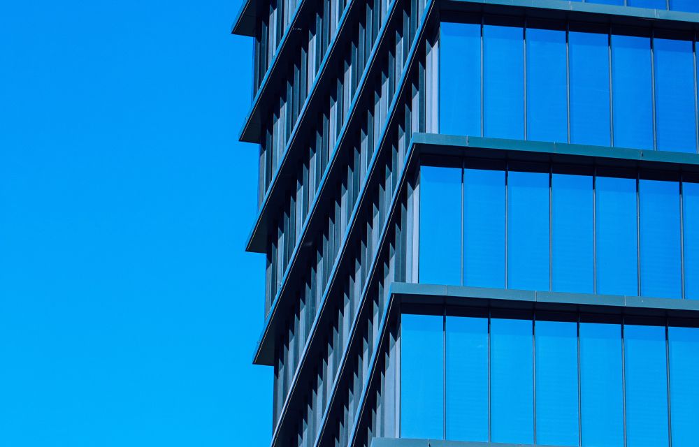 a business centre with blue skies reflected in the glass